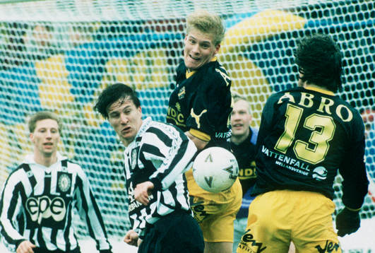 Johan Mjällby nickar undan bollen framför Peter Harrysson