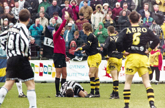 Domare Anders Frisk delar ut en varning till Jesper