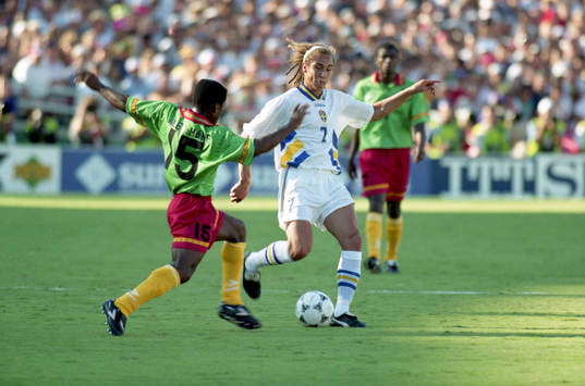 Agbo, Kamerun försöker ta bollen ifrån Henrik Larsson,