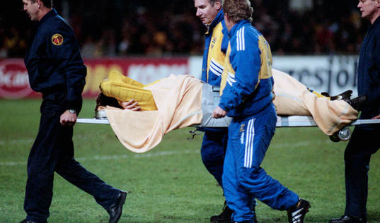 Tomas Brolin, skadad, bärs ut på bår