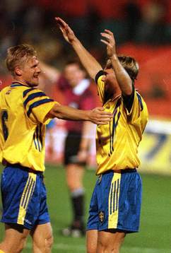En glad Andreas Andersson gratuleras av Johan Mjällby