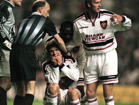 Jesper Blomqvist hjälps upp av Andy Cole och David Beckham